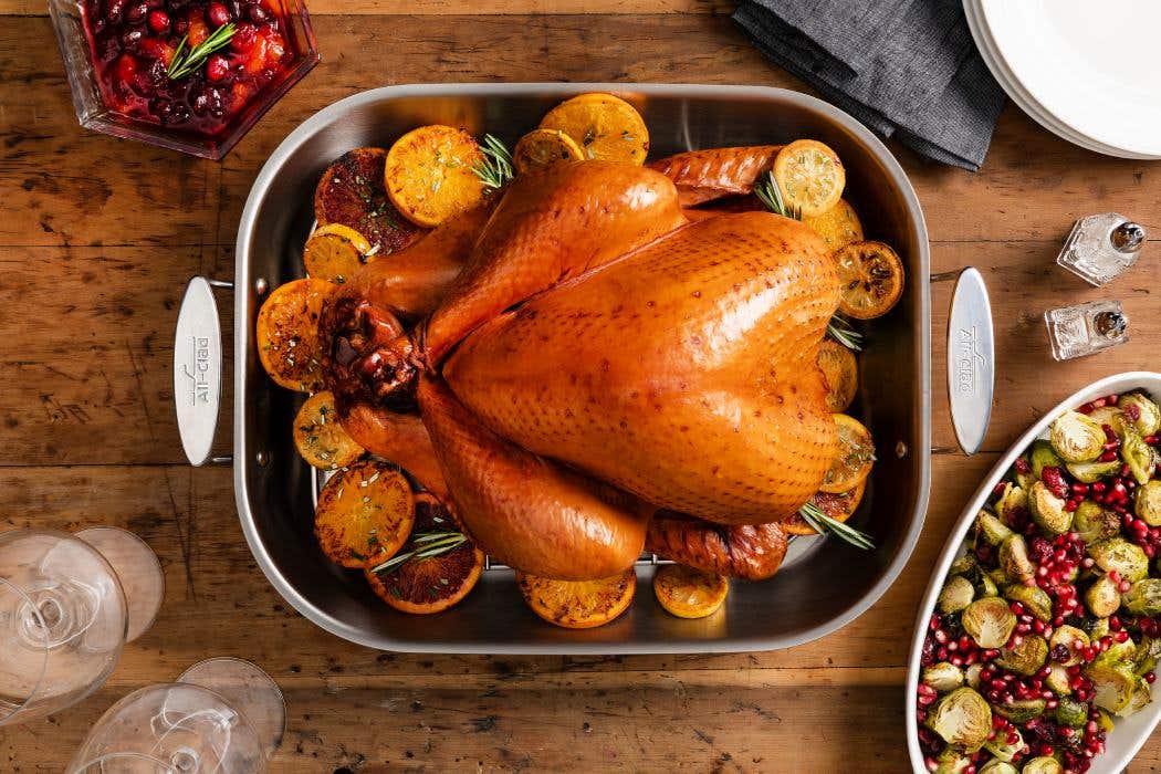A golden-brown turkey sits prominently on a table, complemented by an assortment of traditional holiday dishes.